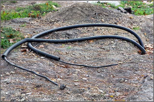 An image of cable in a protective PVC buried under