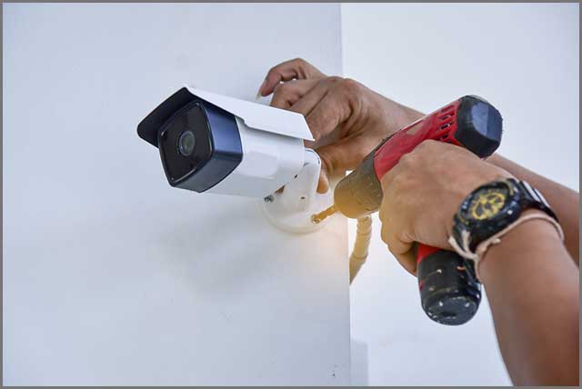 Technician installing CCTV camera for security