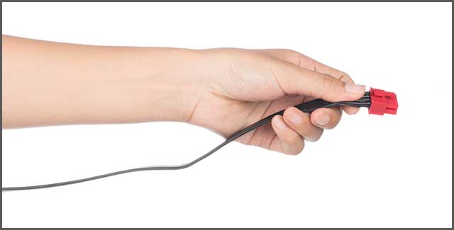 A hand holding power cable