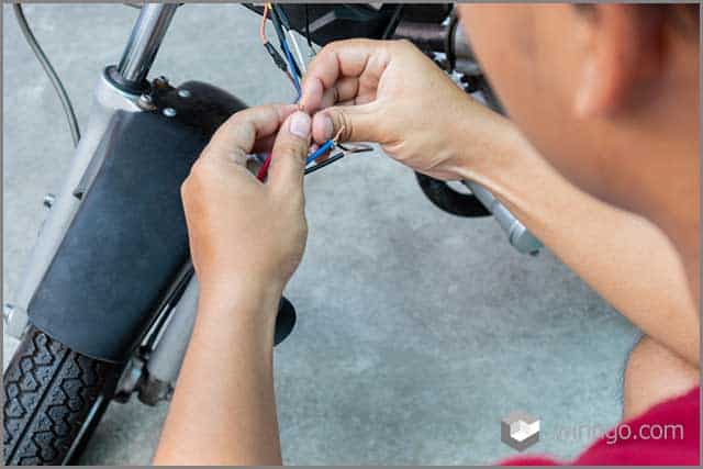 Mechanic man wiring the electrical cables motorcycle