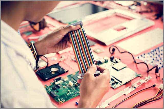 A technician holding the flexible flat cable in a workshop