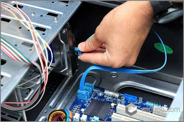 An image of close up technician's hands wiring computer mainboard