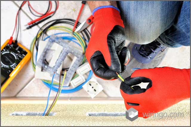 Electrician technician at work prepares the cable