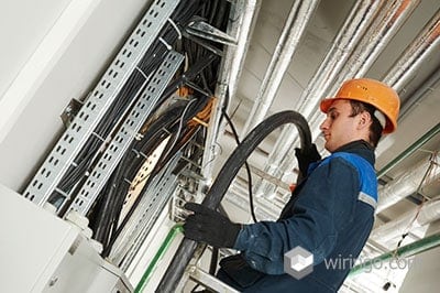 Electrician builder engineer installing industrial cable