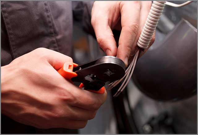 An engineer performing crimping on wires