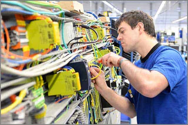 A man assembles electronic components on a machine