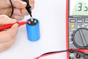 Electrician testing a capacitor with a multimeter