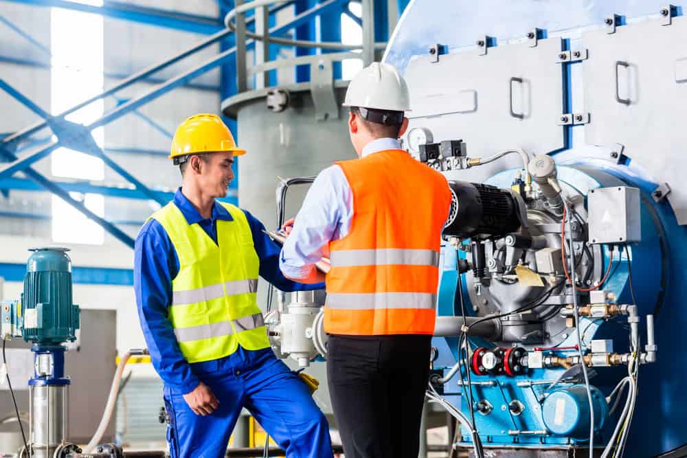 Manager and worker discussing the machine in a factory