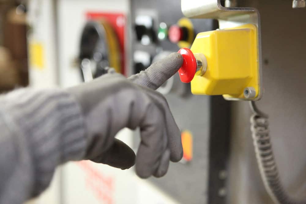 A factory worker pushing a button