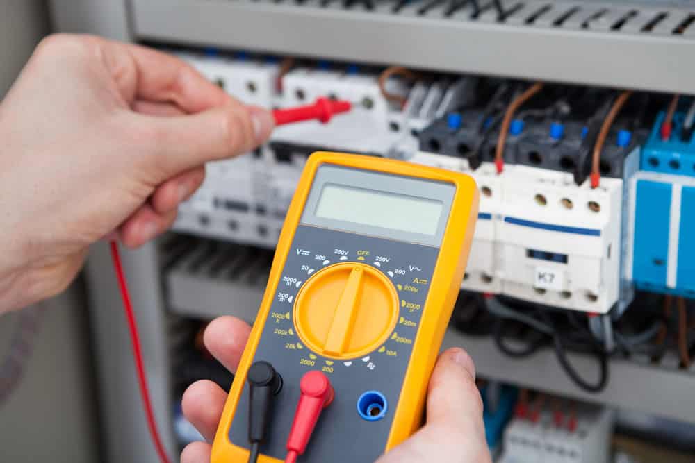 An electrician examining a fuse box