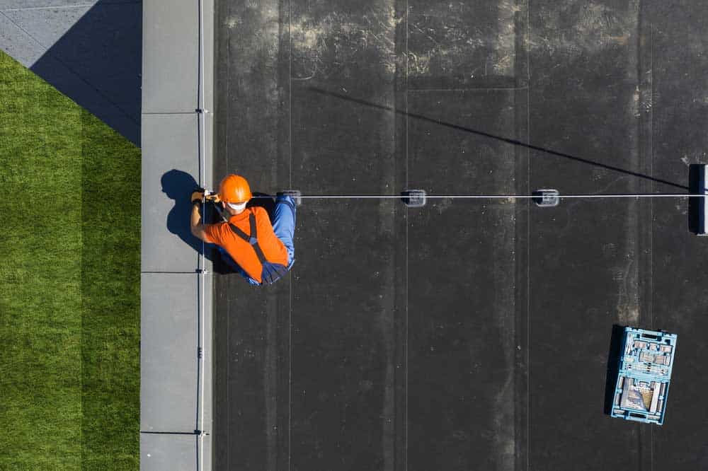 technician installing lightning protection system rod on top of a building
