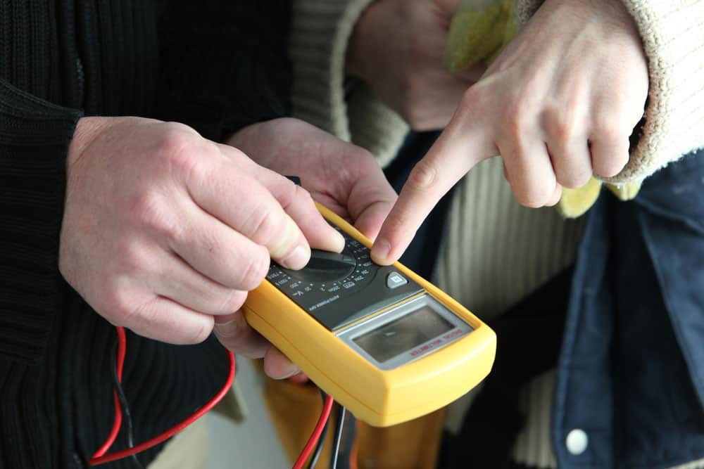 Electricians using a tester