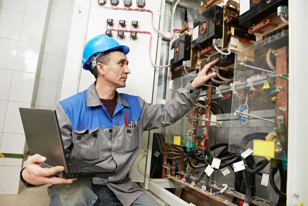 Caption: Technician inspecting main power system using technology
