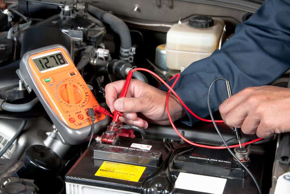 A mechanic checking battery car voltage