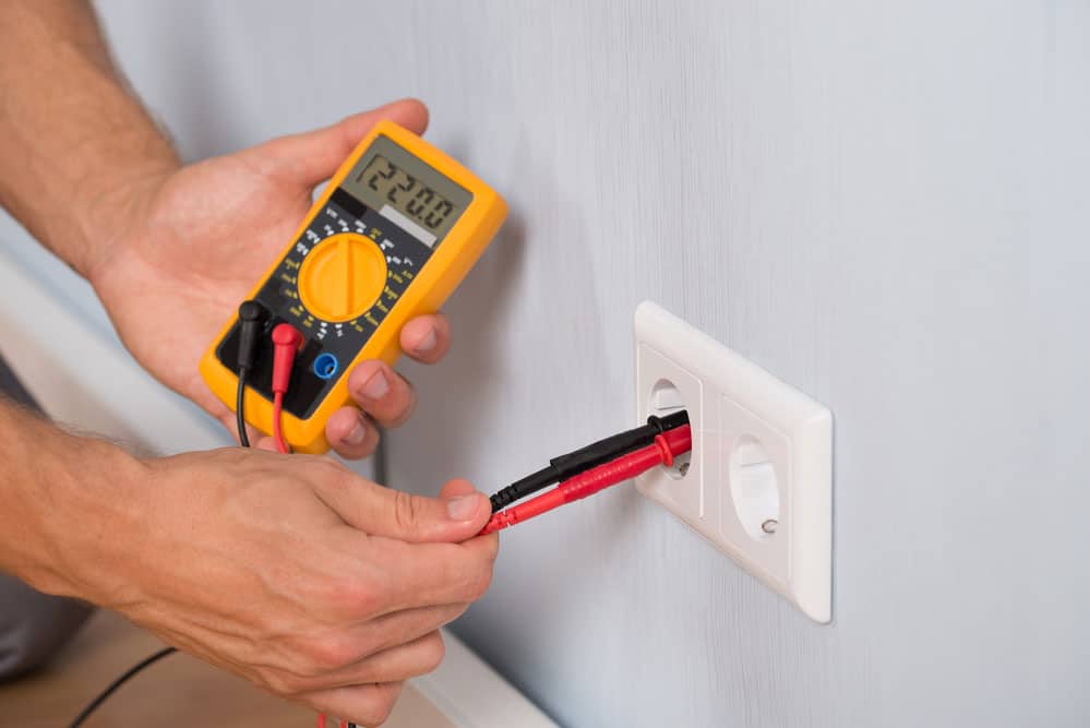 An electrician checking socket voltage