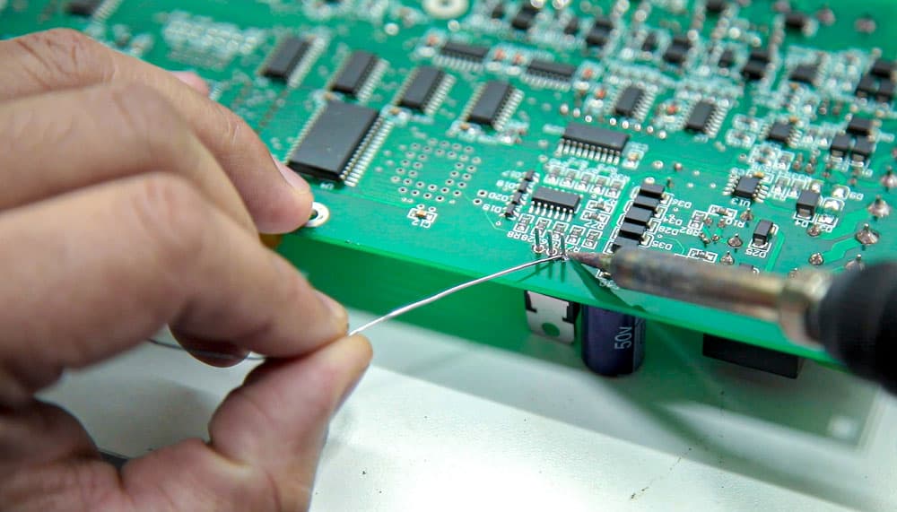 Manual electronics soldering and oscilloscope testing