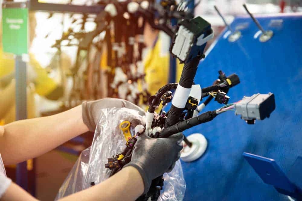 Worker setting up a wire harness in the production line