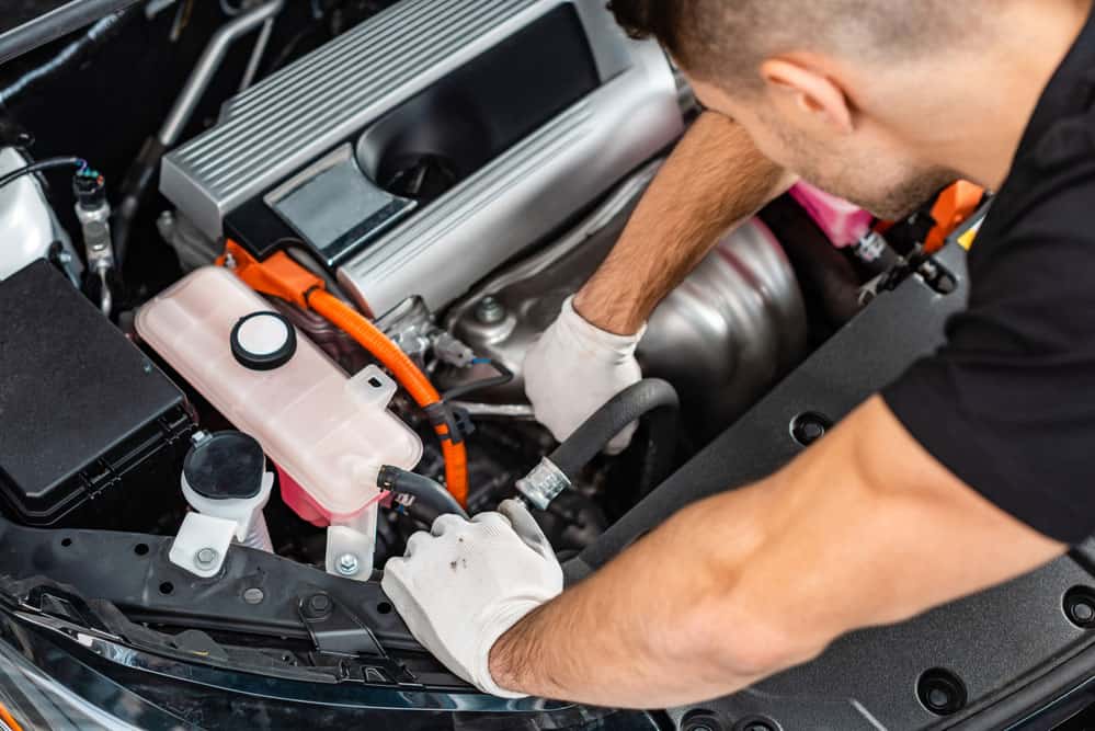 A car mechanic inspecting the wiring harness